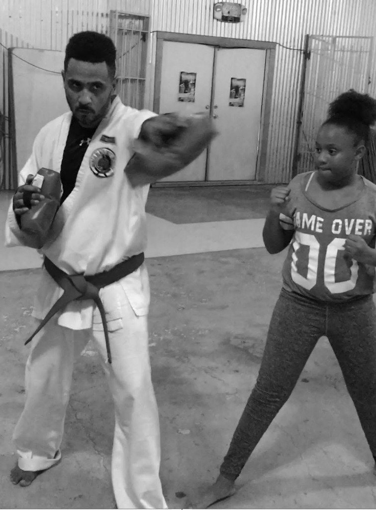 Sensei training young student in punch defense and target focus